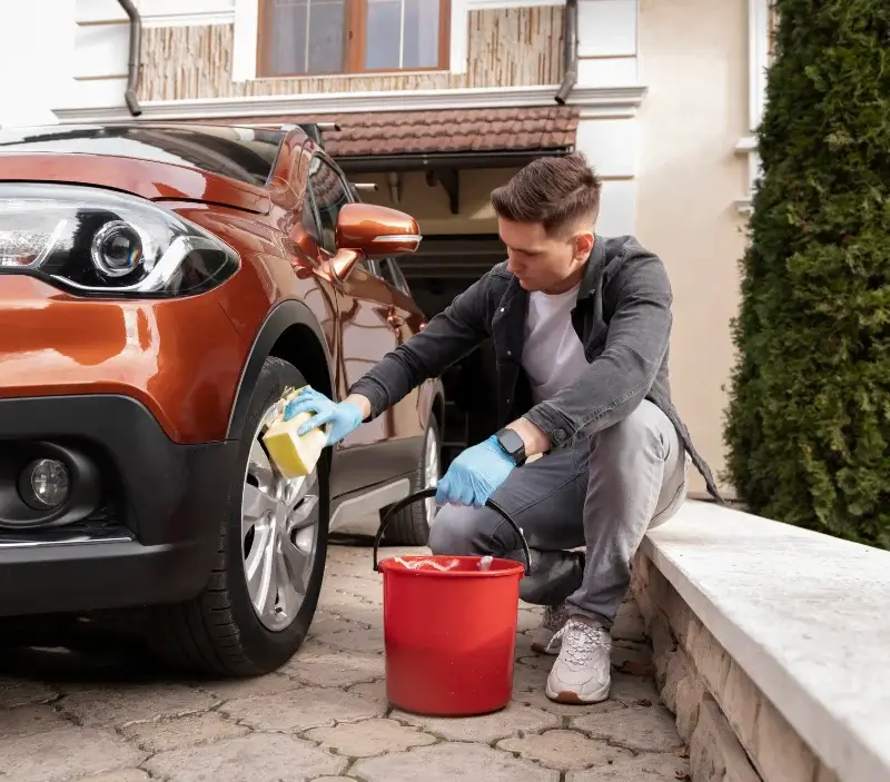 Lavage auto à domicile Dom-le-Mesnil : professionnel intervenant sur un véhicule